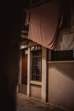 view of narrow street with dry clothes on rope in old quarter at night, Venice, Italy  clipart