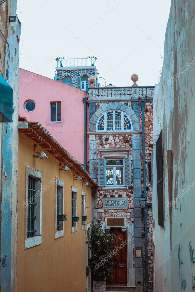 view of narrow street among houses in old quarter , Lisbon, Portugal