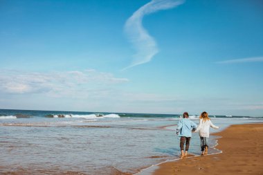 Çift el ele tutuşarak ve having fun sahil, Fas, kumlu Sahilde yürürken aşık
