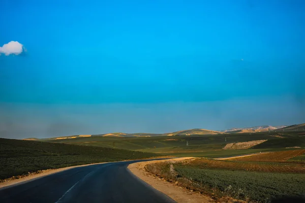 Festői Kilátás Nyílik Üres Road Végtelen Zöld Dombok Napsütéses Napon Stock Fotó