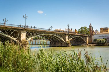 Pozlama Seville, İspanya ve gün batımından önce nehir Triana Köprüsü.