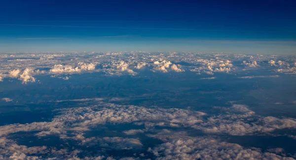 Bulutlar ve dağların Orta Avrupa'da gösterilen uçak penceresinden görüntülemek.