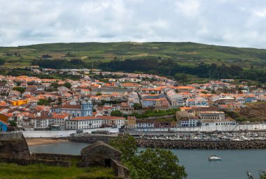 Angra do Heroismo 'nun panoramik görüntüsü Terceira Adası, Azores, Portekiz. Kırmızı çatılar, marina ve yeşil tepeler Monte Brasil 'den Atlantik Okyanusu manzaralı..