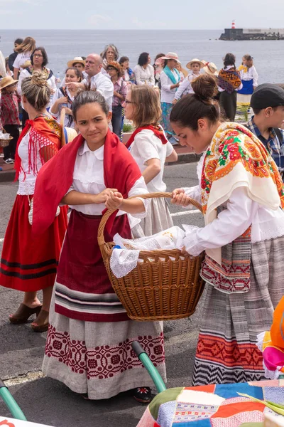 Ponta Delgada, geleneksel kıyafet giyen ve ilahi kutsal ruh kutlama bir hasır sepet tutan Azores, Portekiz - 07/07/2018 - iki genç kız