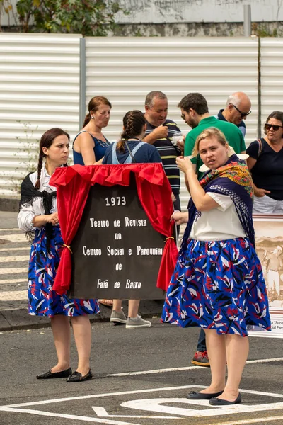 Ponta Delgada, geleneksel kostümler giyen ve poster ilahi kutsal ruh kutlama üzerinde tutarak Azores, Portekiz - 07/07/2018 - iki genç kadın