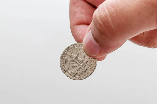 Çeyrek dolar sikke, beyaz arka plan tutan erkek el