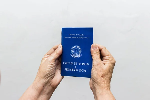 手白种人的资深妇女拿着工作书 巴西社会保障文件 — 图库照片