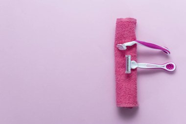Depilasyon blade ve havlu, pembe bir arka plan
