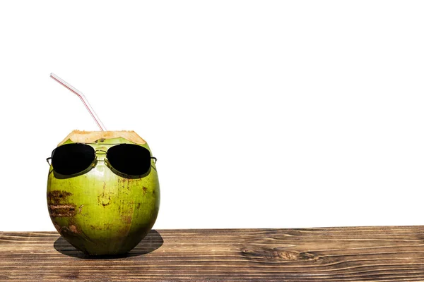 coconut with sunglasses on wood, white background, space for text