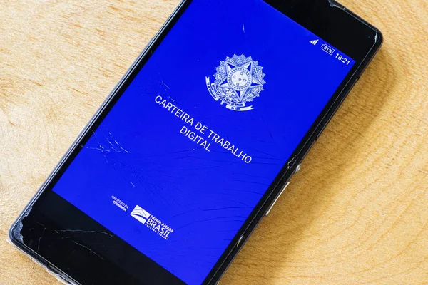 yeni Brezilya dijital iş cüzdanı ile eski akıllı telefonun kırık ekranında yakın