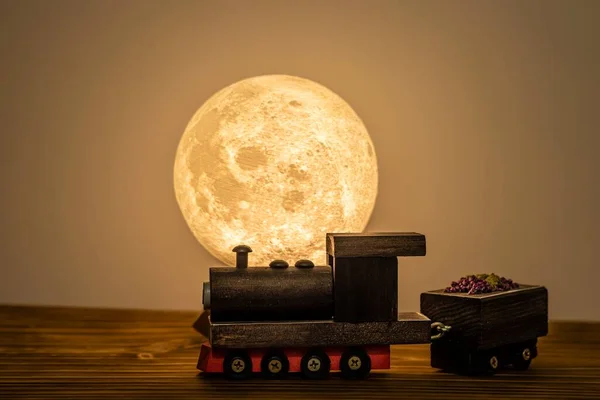 Masasında ay ışığı olan küçük ahşap tren.