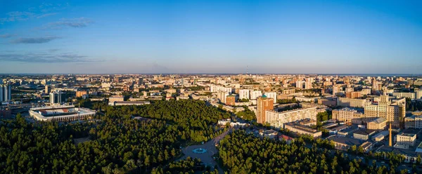Panoramic drone view of Chelyabinsk city, huge park with mixed forest in the city center and college campus, sunny evening in the capital of South Ural, Russia