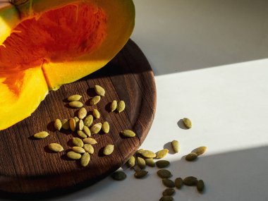 Güneş kabak ahşap üzerine mutfakta; lezzetli hasat kahverengi resepsiyon ve beyaz masa; dilimlenmiş kabak kutlama yemek için; sağlıklı gıda ve Cadılar Bayramı kavramı; Sonbahar minimalist sebze dekorasyon