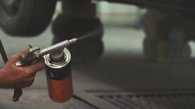 Otomobil tamiri süreci; mekanik hasarlara karşı araba organları korumak için Tamircinden madde püskürtme; hizmet işçisi hasarlı araba düzeltmek; metal gövdesi, yumuşak odak düzeltmek için ekipman ile çalışma