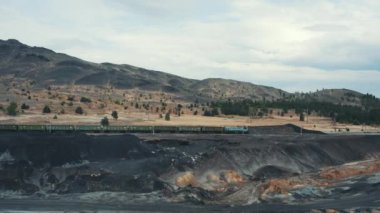 Tren siyah dökümleri arasında ileri hareket, kirlenmiş arazi, hiçbir bitki örtüsü. doğada insanların antropojenik etkisi ile korkunç manzara. Eski bitki taşıma sistemi. Havadan görünüm
