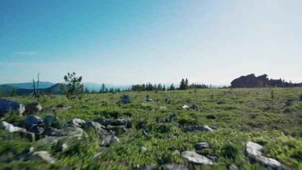 Drohne fliegt bei Sonnenuntergang vorwärts über Gebirge. Silhouette der Gipfel des Berges — Stockvideo