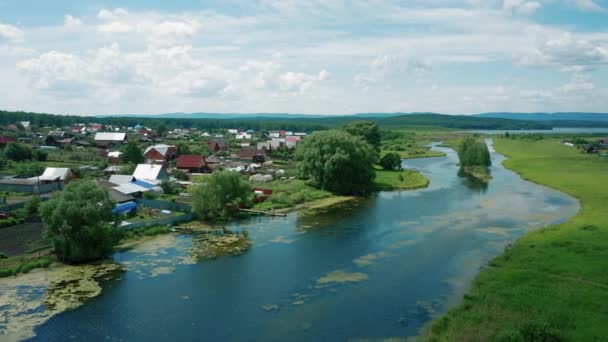 Luchtfoto 's. Drone vliegt over rivier in het dorp op zonnige zomerdag — Stockvideo
