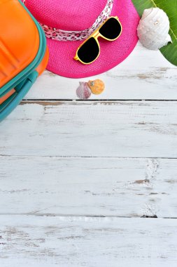 İş zor tatil zaman yolculuğu sonra dinlenme, yaz sezonu seyahat çantası kamera plaj şapka güneş gözlüğü ile beyaz ahşap arka plan üzerinde dikey biçimi