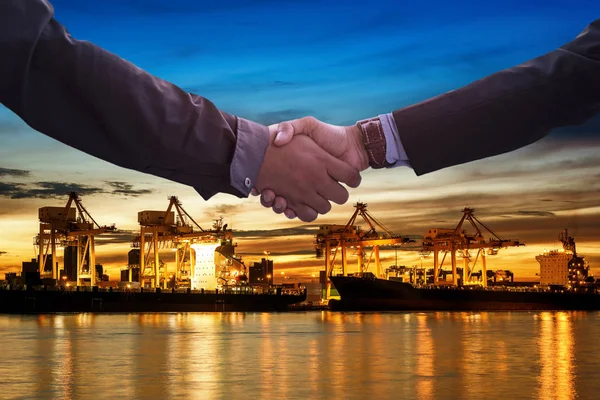 Business Collaboration, Businessman shake hands with logistics and transportation of container cargo port with working logistic import and export industry.