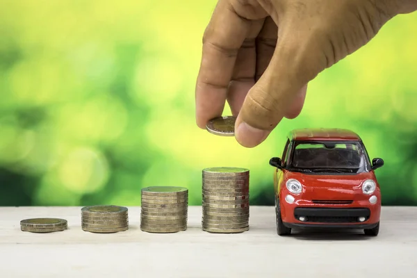 Car Loan concept, Red car have many coin and green bokeh background