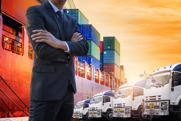 Businessman pose crossed arms and Transportation port shipyard import export concept, Container on the ship at port in the morning, Schedule ship into stock