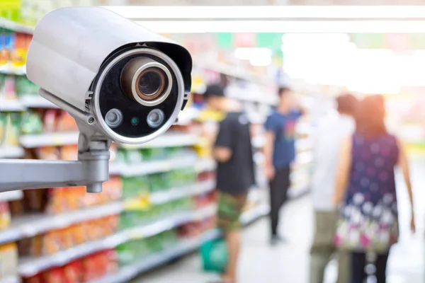 Security CCTV camera in supermarket with people shopping in supermarket blur background