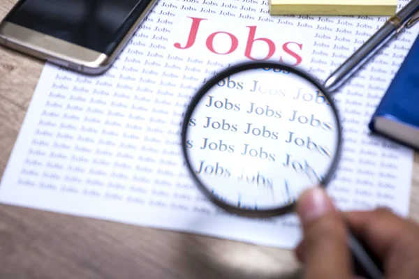 İş arama kavramı, iş arama için Büyüteç Camı tutan el.