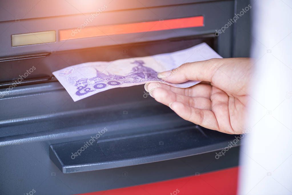 Hand receive bank note from ATM machine, employee salary financial concept