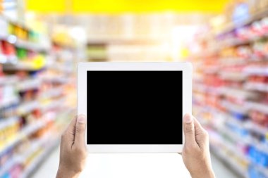 Dijital tablet süpermarket alışveriş merkezi ile holding eller arka plan bulanıklık