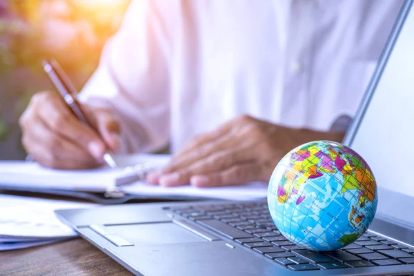 Businessman working with world model on the computer laptop