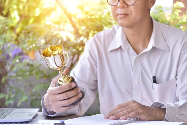 Businessman working and holding gold trophy, Business challenge