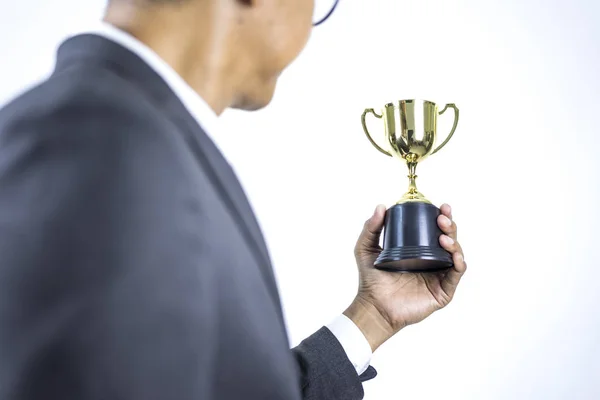 Businessman holding gold trophy on white isolated background, Business success