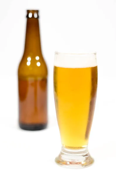 Vaso Cerveza Lleno Espuma Con Una Botella Vidrio Marrón Lado —  Fotos de Stock