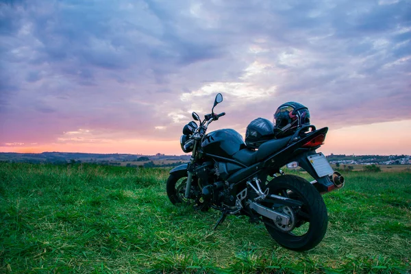 Siyah bir motosiklet kaskı, siyah bir motosikletin koltuğuna yerleştirilmiş..