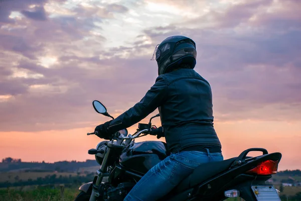 Mężczyzna Siedzący Czarnym Motocyklu Niebieskich Dżinsach Czarnej Kurtce Czarnym Hełmie — Zdjęcie stockowe