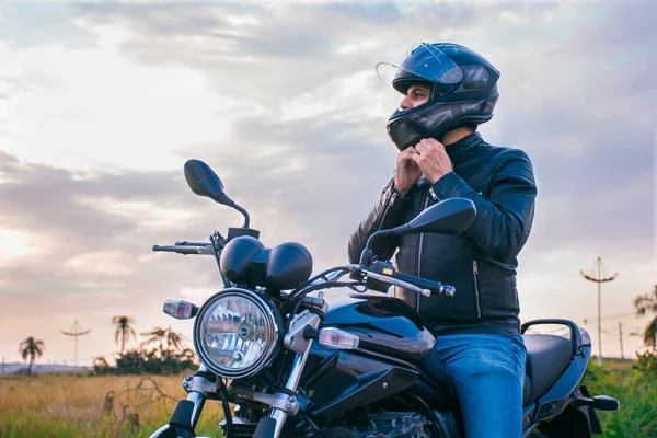 Чоловік Сидить Мотоциклі Носить Джинси Чорну Куртку Кріпивши Свій Шолом — стокове фото