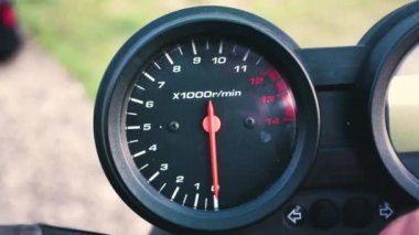 Bir motorsikletin hız göstergesi hızın maksimum seviyeye ulaştığı ve tekrar düştüğü kırmızı iğne..