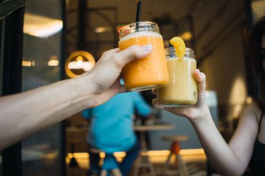 Ürün Görünümü eller erkek ve kadın üzerinde parlak içecekler ve payet ile kokteyl kavanoz tungur Kafe'nin arka plan bulanık