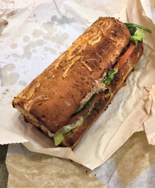 Kızarmış ton balığı öğütücüsü. Bitki ve peynirli ekmeğin üzerinde. Paketin üzerinde duruyor.