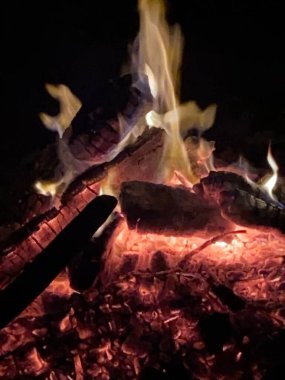 Odunlar, kömürler ve közlerle dolu bir çukurun içinde bir ateşe yaklaş.