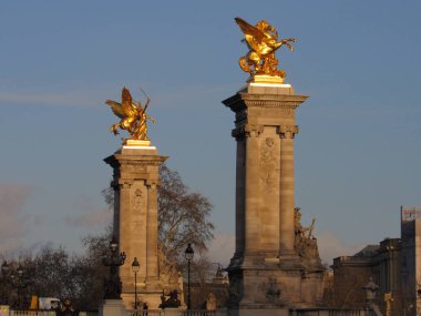 Paris, Fransa 'da gün batımında Seine nehri boyunca uzanan Pont Alexandre III köprüsü.