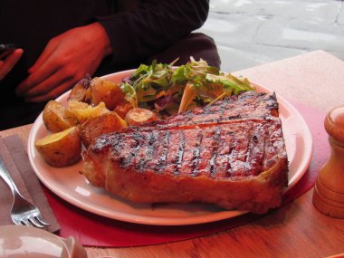 Floransa, İtalya 'da bir restoranda bir tabak geleneksel Floransa bifteği, patates ve salata. 