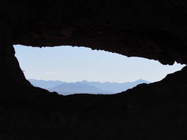 Phoenix ve Tempe, Arizona 'daki Papago Park' taki kayalıklardaki deliğin oluşumuna bakın. Arka planda dağlar ve mavi gökyüzü.