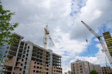 Mavi arka planda kule vinci olan modern apartman binası