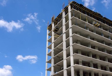 Mavi gökyüzü arka planında inşaat sırasında modern apartman betonu bina