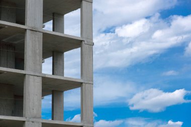 Mavi gökyüzü arka planında inşaat sırasında modern apartman betonu bina