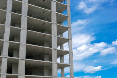 Mavi gökyüzü arka planında inşaat sırasında modern apartman betonu bina