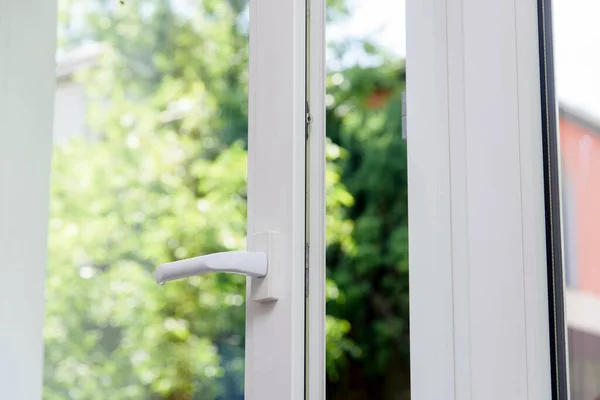 Plastik pencere açıldı. Yeşil yapraklar arkaplan.
