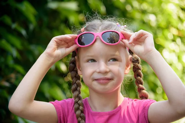 Portret Małej Białej Dziewczynki Okularach Przeciwsłonecznych Zielonym Tle — Zdjęcie stockowe