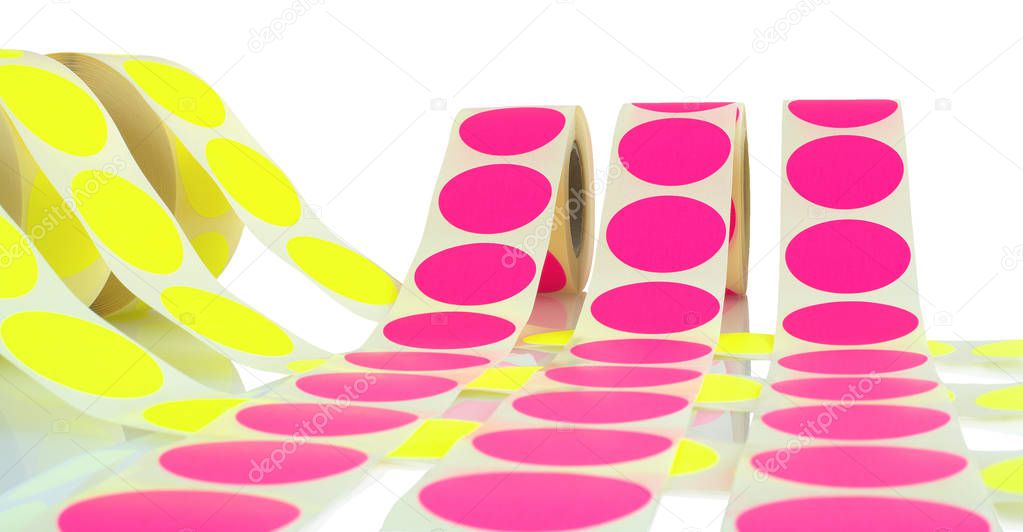 Colored label rolls isolated on white background with shadow reflection. Color reels of labels for printers. Labels for direct thermal or thermal transfer printing. Yellow and pink labels background.